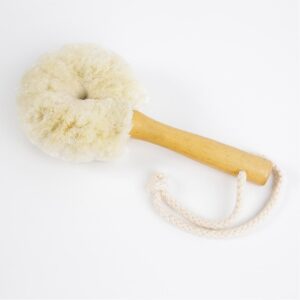 Facial Cleansing Brush with wooden handle for easy use. At the base of the handle is a cotton rope to use to hang the brush in between use. On a white background