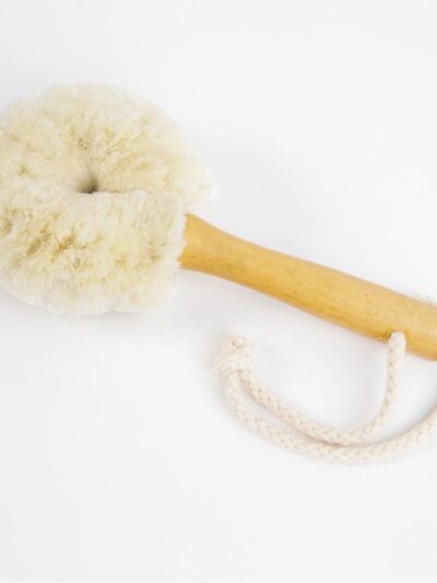 Facial Cleansing Brush with wooden handle for easy use. At the base of the handle is a cotton rope to use to hang the brush in between use. On a white background