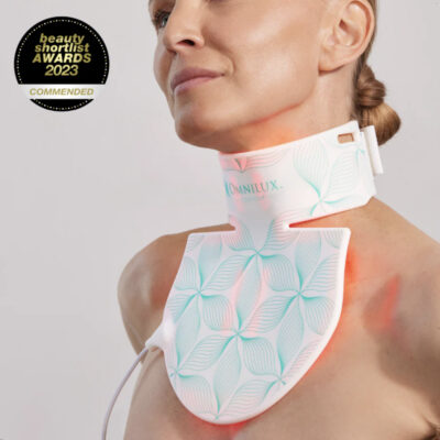 Woman with her Medical Grade OMNILUX CONTOUR Neck and Decolletage Mask set to red LED light.